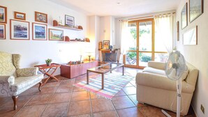 Un salon avec une cheminée, un canapé, une table basse et un ventilateur.