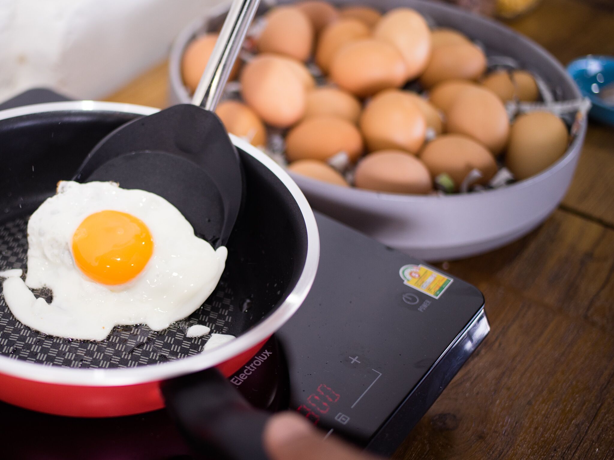 A frying pan with a sunny-side-up egg on a digital electric stove.