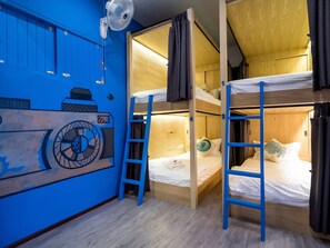 A room with bunk beds, a fan, and a wall mural. - Bed in 8-bed Mixed Thalay Cha Am by Tha A Co-living With a Million Dollar View - Hostel (Cha-am)
