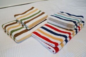 Une pile de serviettes pliées, à rayures et de différentes couleurs.