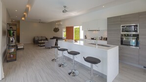 Una cucina moderna con isola centrale, sgabelli da bar ed elettrodomestici integrati.
