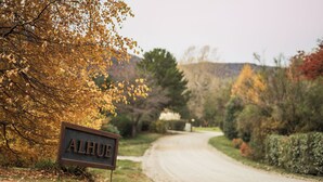 A rural road with a sign reading 'ALHUE' and autumn foliage. - Alhue - Casa en el Golf (San Carlos de Bariloche)