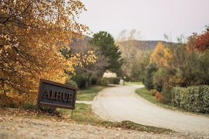 Une route de campagne avec un panneau indiquant « ALHUE » et des feuilles d’automne.