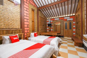 A room with two beds, a bench, a mirror, and a checkered floor.