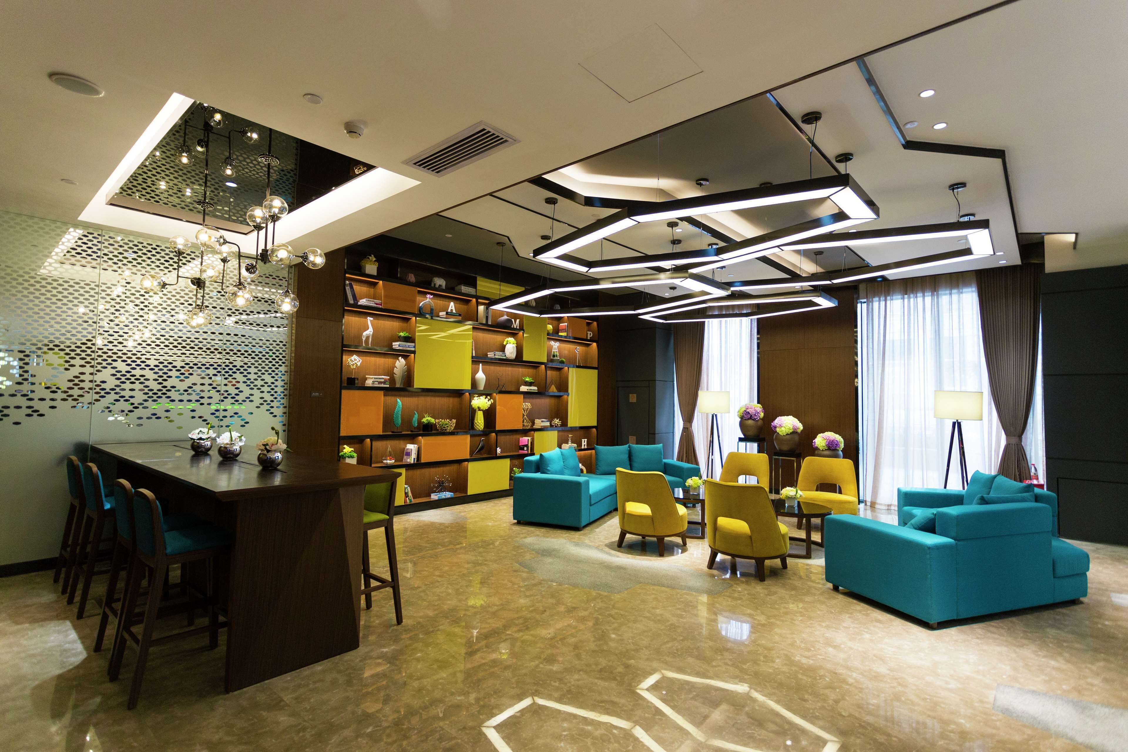 A modern lounge area with a bar, seating, and a bookshelf.