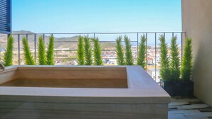A balcony with a rectangular planter, a railing, and a view of a town and hills in the distance. - Best Louis Hamilton Hotel West Busan (Busan)