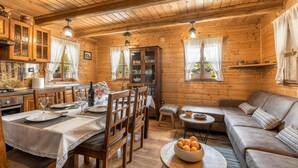 Un interior acogedor de cabaña con comedor, sofá y cocina.