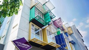 A hotel building with colorful balconies and a sign indicating it is Hotel Panteles Karanganyar. - Hotel Pantes Simpang Lima Semarang (Semarang)