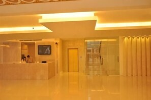 A reception area with a reception desk, a television, and a door leading to another room.
