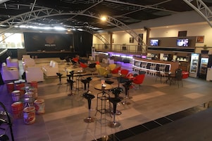 Un espacio lounge moderno con escenario, asientos y bar.