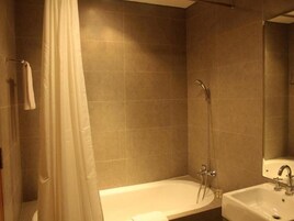Un baño con bañera, lavamanos y ducha.