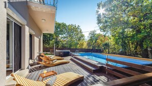 A poolside area with wooden loungers, a hot tub, and a clear view of the pool. - 3 bedroom nice home in Srinjine (Srinjine)