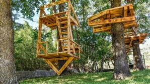 A wooden structure with a staircase, surrounded by trees and grass. - 3 bedroom nice home in Srinjine (Srinjine)