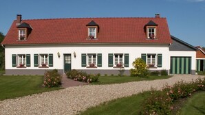 A two-story house with a red-tiled roof, green shutters, and a gravel driveway. - MIL ROSES EN BAIE 9 PEOPLE NEAR MARQUENTERRE (SAINT QUENTIN EN TOURMONT)