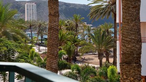 A resort with palm trees, a pool, and a mountain backdrop. - 211 Los Cristianos First Sea Line, Swimming pool (Los Cristianos)
