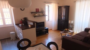 Een gezellige, compacte ruimte met kitchenette, eethoek en zithoek.
