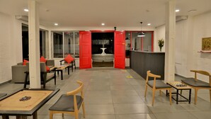 A spacious lobby with a foosball table, seating area with chairs, and a reception desk. - Ritz Heritage (Mawal)