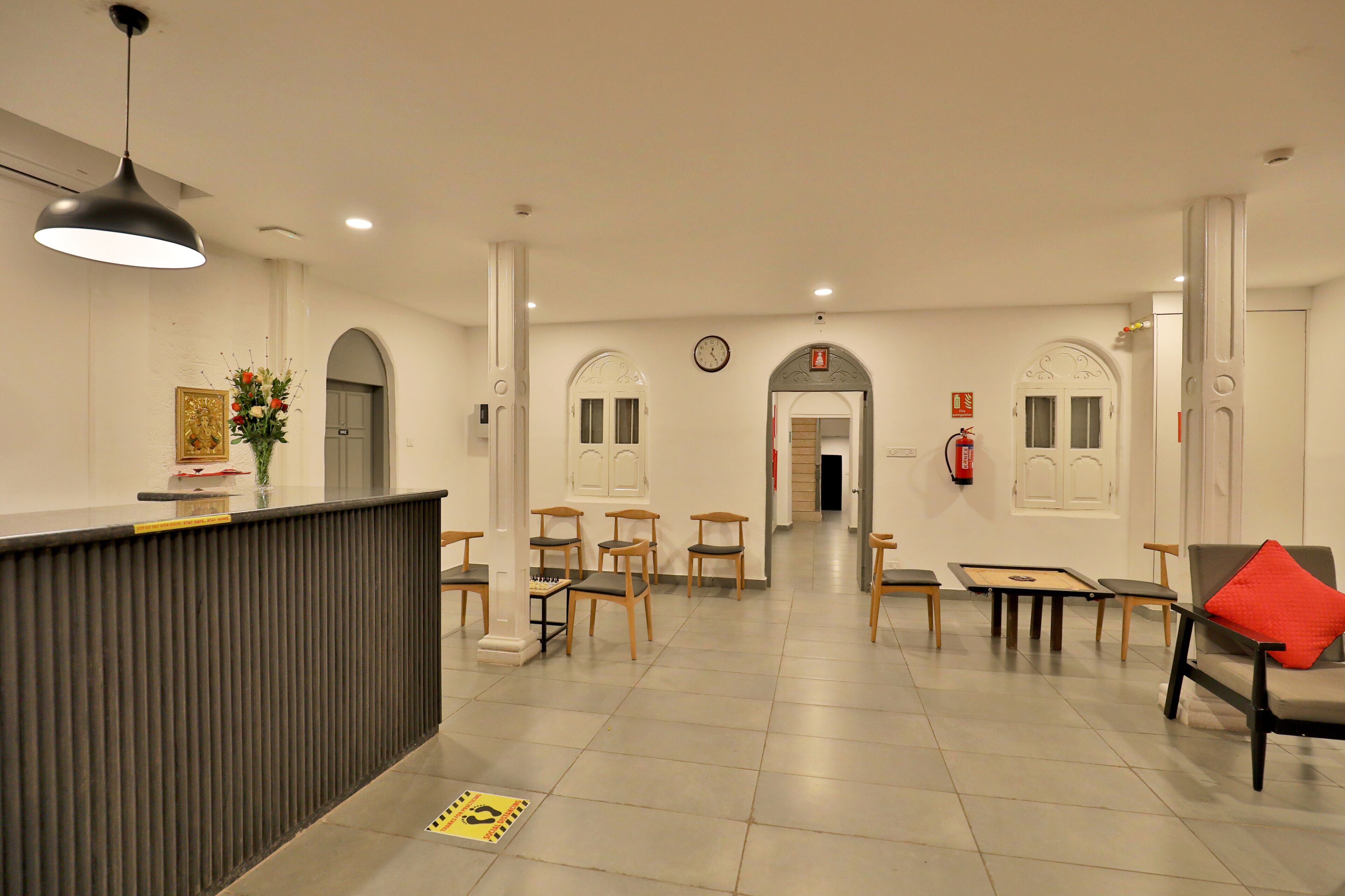 A reception area with a counter, chairs, a clock, and a fire extinguisher.