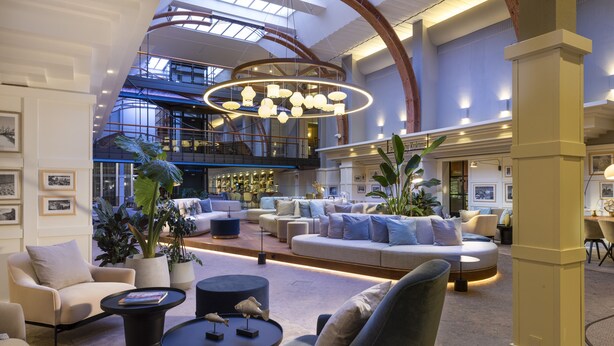Un hall d’entrée spacieux, doté d’un plafond haut, d’un éclairage moderne et d’espaces de détente confortables.