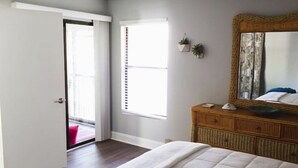 A bedroom with a bed, a dresser, a mirror, and a window. - Immaculate Fort Myers Condo, ideal location-quiet (Fort Myers)