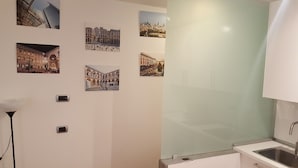 Une salle de bain dotée d’un lavabo moderne, d’un miroir et d’une cabine de douche en verre.
