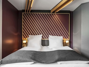 A modern bedroom with a bed, two bedside tables, and a geometric-patterned headboard. - B&B Hotel Schweinfurt-City (Schweinfurt)