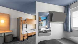 Ein modernes Hotelzimmer mit Etagenbett, Schreibtisch und Stuhl, einem kleinen Hocker, einem an der Wand befestigten Fernseher und einem Fenster mit Vorhängen.