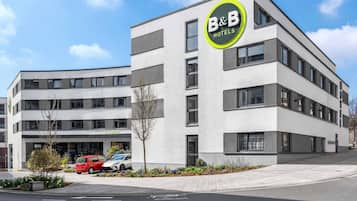 Ein modernes Bed & Breakfast Hotel mit Empfangsbereich, Parkplätzen und blauem Himmel.