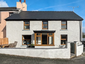 A two-story house with a dark roof, white exterior walls, and wooden-framed windows. - 3 bedroom accommodation in Mathry (Mathry)