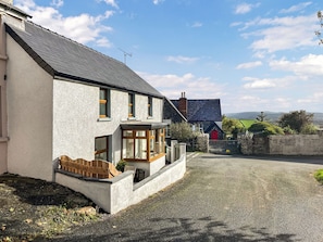 A two-story house with a gravel driveway and a red door. - 3 bedroom accommodation in Mathry (Mathry)