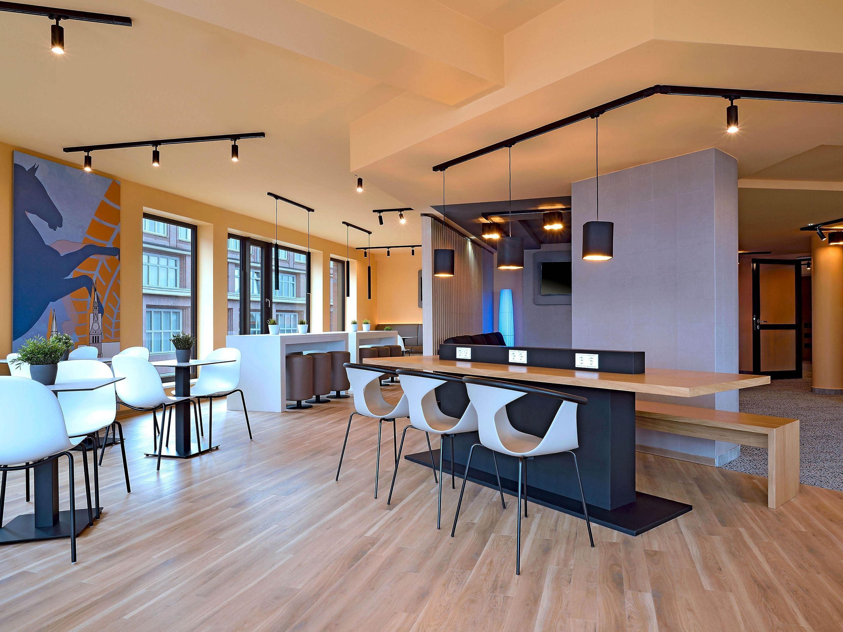 A modern interior with a bar area, seating, and large windows.