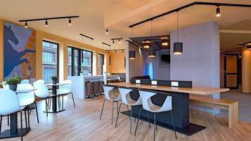 A modern interior with a bar area, seating, and large windows.
