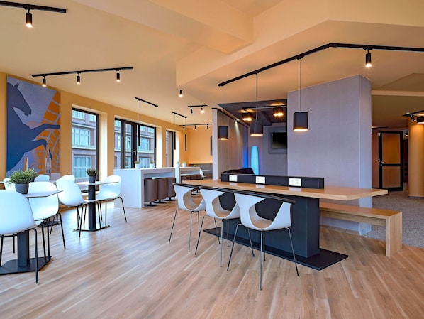 A modern interior with a bar area, seating, and large windows. - B&B Hotel Hannover-City (Hannover)