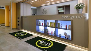 A reception area with a reception desk, a digital display, and a reception sign. - B&B Hotel Hannover-City (Hannover)