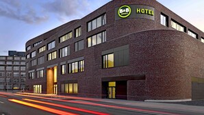 A modern hotel building with a curved facade, multiple windows, and a prominent B&B Hotels sign. - B&B Hotel Hannover-City (Hannover)