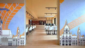 Un interior moderno con un largo pasillo que conduce a un comedor, adornado con un mural de la ciudad en las paredes.