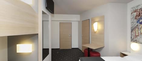 A hotel room with a bunk bed, a desk, a chair, a mirror, and a wall-mounted TV.