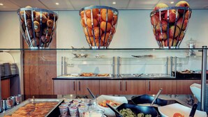Un bufé con diferentes opciones de comida y una presentación de frutas.