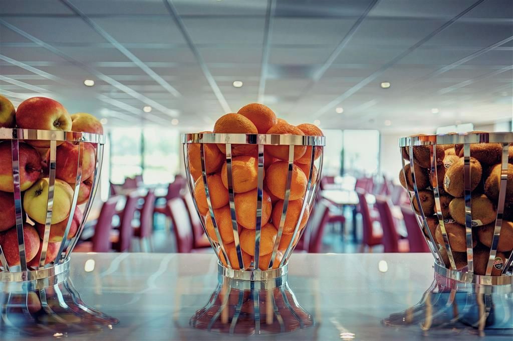 Three glass bowls filled with fruits on a table in a modern interior.