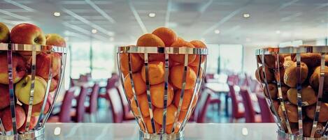 Three glass bowls filled with fruits on a table in a modern interior.