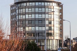 Un bâtiment moderne à plusieurs étages, doté d’une façade incurvée et de grandes fenêtres.