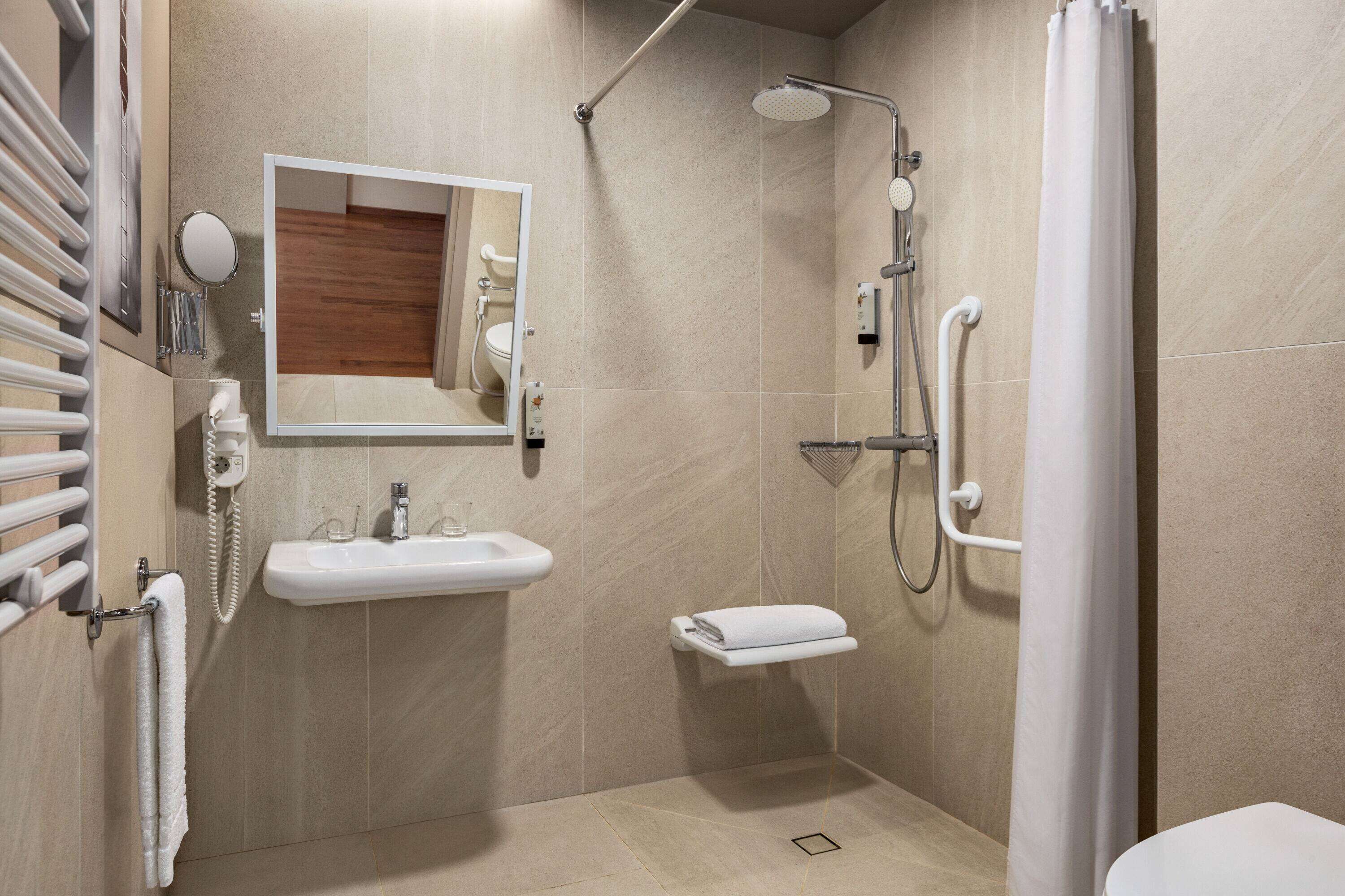 Een moderne badkamer met douche, wastafel en toilet.