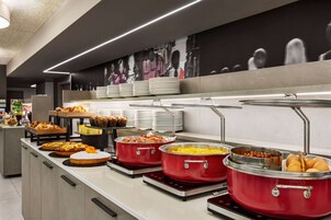 Tavolo per buffet con diversi cibi e una parete con fotografia in bianco e nero.