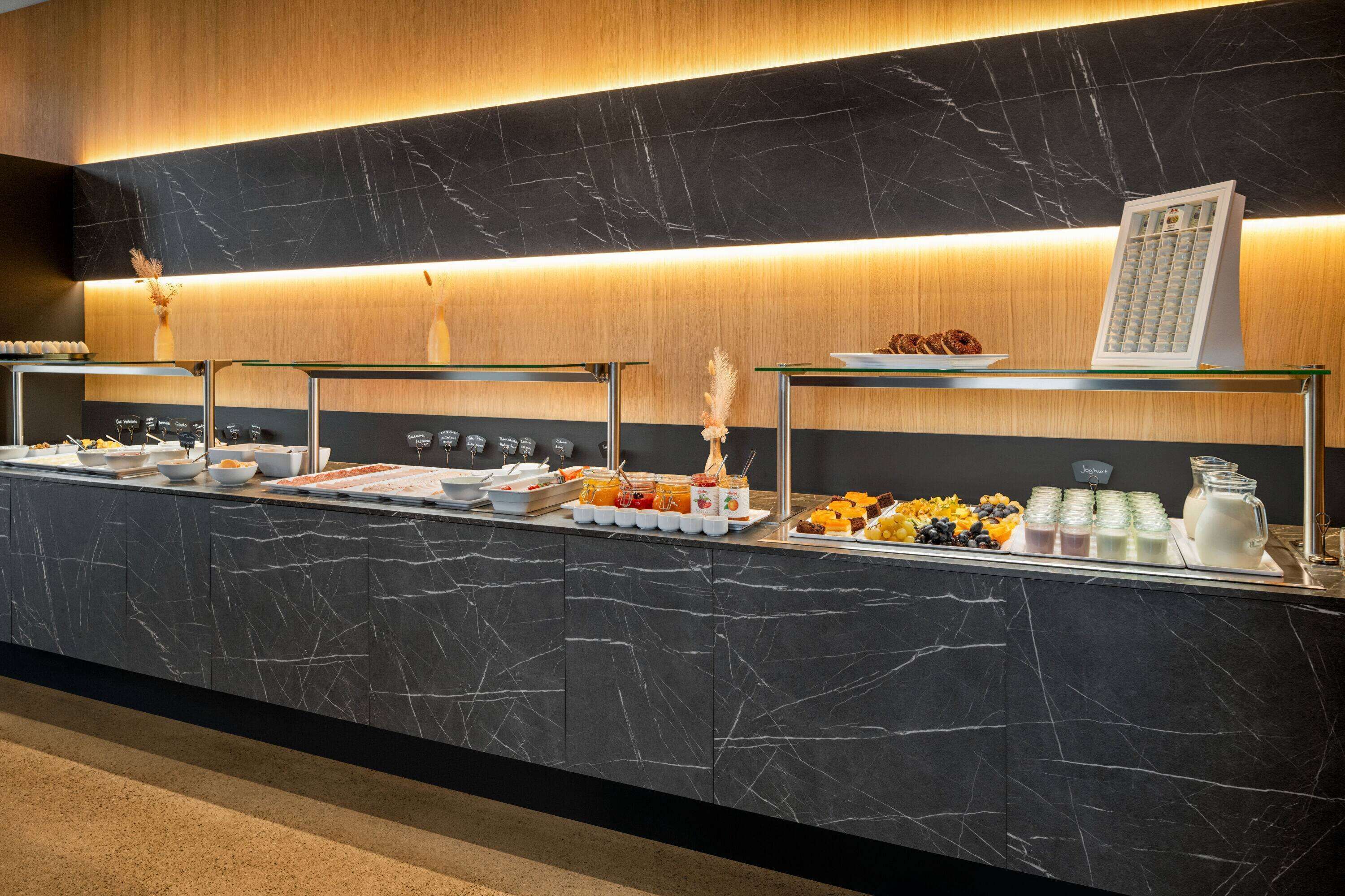 Un buffet proposant une variété de plats et un espace dédié aux boissons chaudes, notamment au café.