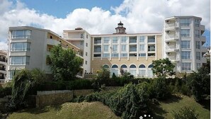 A multi-story residential building with balconies, a central tower, and a well-maintained garden area. - Menada Galateya Apartments (Sveti Vlas)