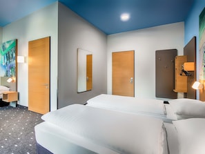 A hotel room with a bed, a nightstand, a mirror, and a wardrobe. - B&B Hotel Chemnitz (Chemnitz)