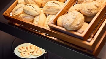 A display of various baked goods, including bread and pastries, arranged in wooden trays.