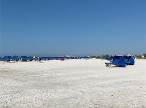 Relax on the beach with comfortable seating and shade under the umbrellas.
