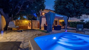 An outdoor pool area with a stone patio, a hot tub, and a covered seating area. - Villa Natura (Benkovac)