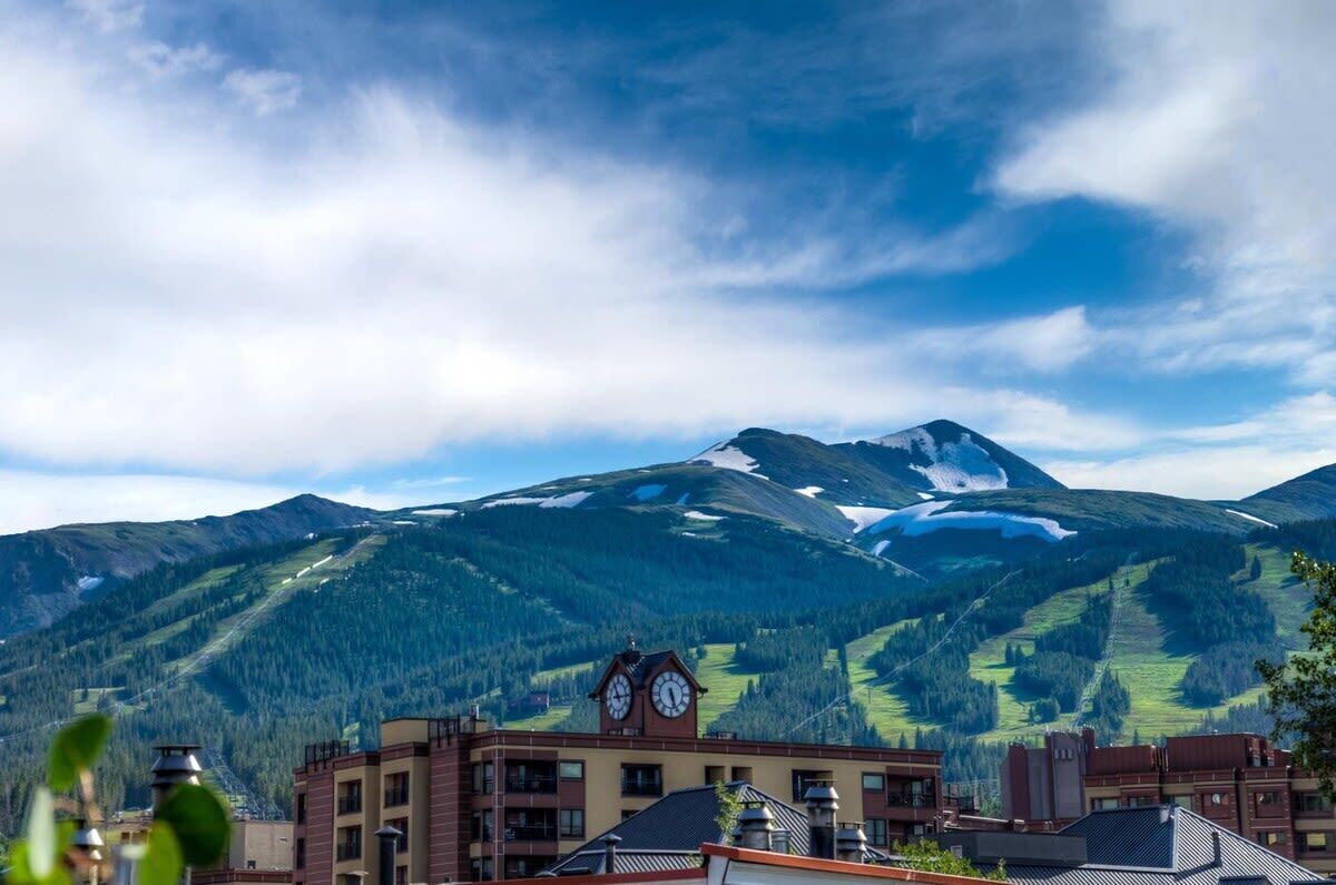 A mountain landscape with a building featuring a clock tower.